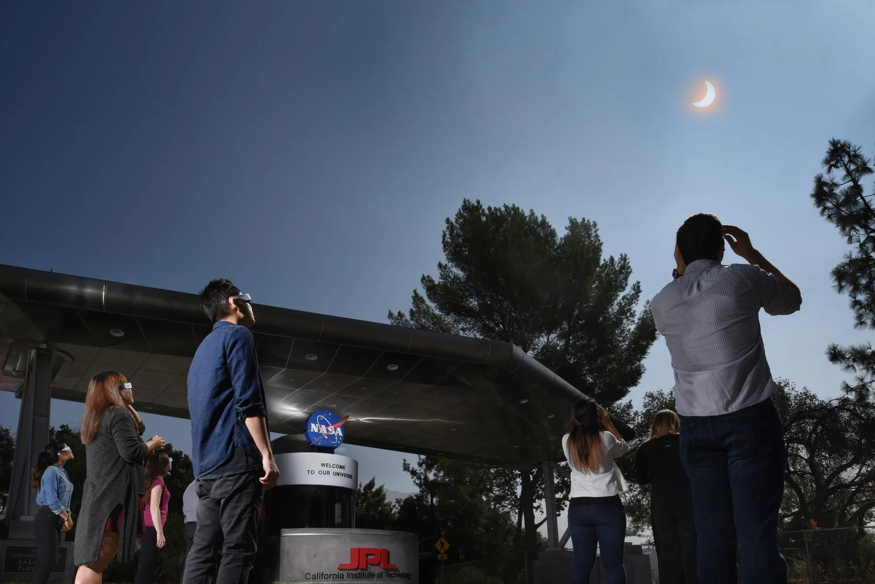 People at NASA's Jet Propulsion Laboratory look skyward through solar viewers during the August 21, 2017 eclipse
